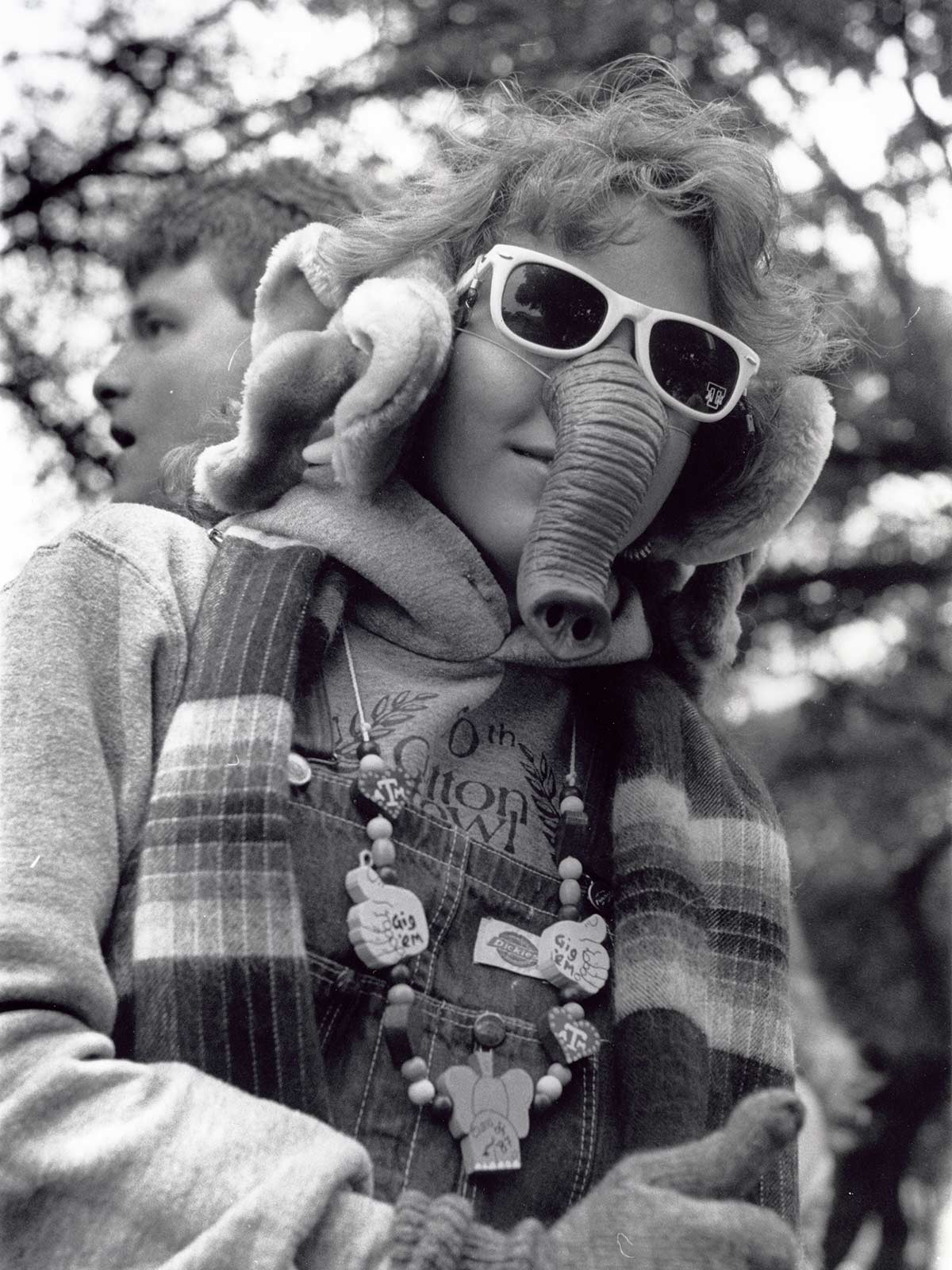 Photo of student wearing sunglasses and faux elephant nose and ears giving a thumbs up