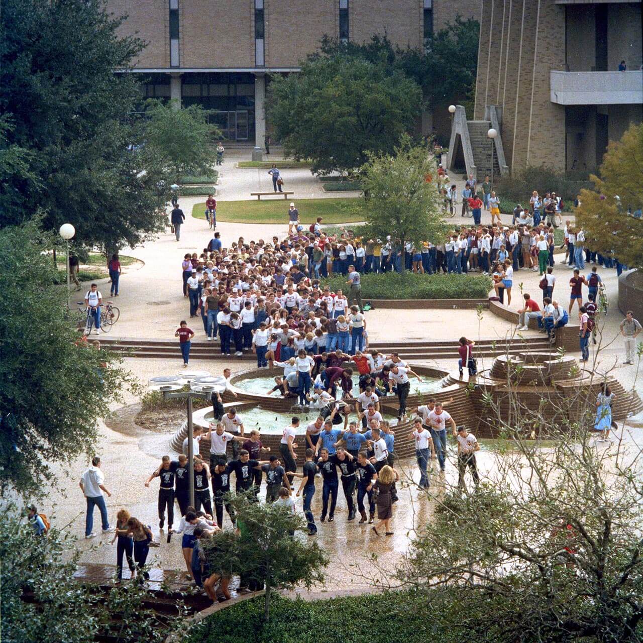 Color photo of Texas A&M students marching through a fountain during Elephant Walk.